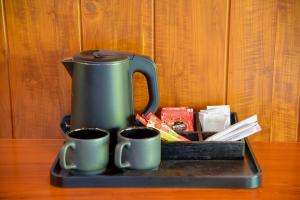 a coffee maker sitting on a tray with two cups at Villa Green Cocos in Katuwana