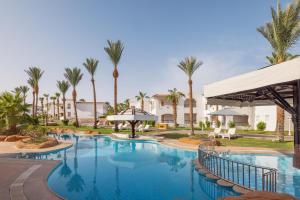 a pool at a resort with palm trees at JAZ Sharm Dreams in Sharm El Sheikh
