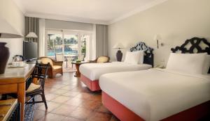 a hotel room with two beds and a desk at JAZ Sharm Dreams in Sharm El Sheikh