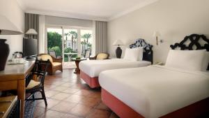a hotel room with two beds and a desk at JAZ Sharm Dreams in Sharm El Sheikh