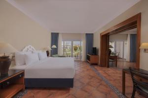 a bedroom with a large white bed and a desk at JAZ Sharm Dreams in Sharm El Sheikh