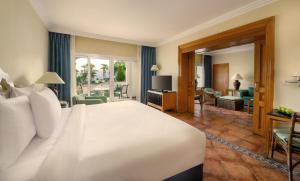 a bedroom with a large bed and a living room at JAZ Sharm Dreams in Sharm El Sheikh