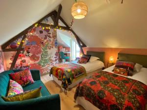 a attic bedroom with two beds and a couch at BENE A CASA Chambres d'hôtes in Veuzain-sur-Loire