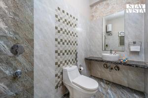 a bathroom with a white toilet and a sink at StayVista at Sitara with Jacuzzi & WiFi in Jaipur