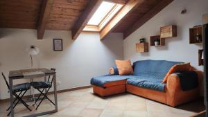 a living room with a couch and a table at La Mansarda sotto il Castello in Magliano Alfieri