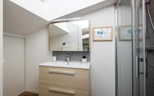 un bagno con lavandino e specchio di Escapade Tropicale fibre, terrasse,parking,clim a Millau Altre 19 foto
