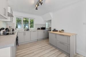 a kitchen with white cabinets and a wooden floor at SPA Cottage With Mineral Water in Stamford