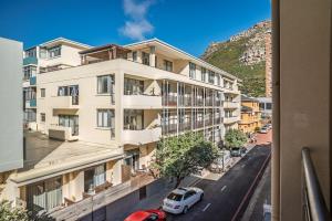 an apartment building with a car parked in front of it at Muizenberg Coastal Hideaway by Surfers Corner in Muizenberg