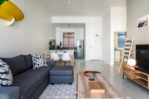 a living room with a blue couch and a table at Muizenberg Coastal Hideaway by Surfers Corner in Muizenberg
