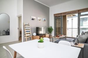 a living room with a white table and chairs at Muizenberg Coastal Hideaway by Surfers Corner in Muizenberg