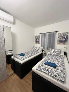 two beds in a room with a mirror at Izabella Apartman Bogács in Bogács +41 photos