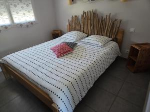 a bed with two pillows on it in a bedroom at Maison familiale avec jardin à Lit-et-Mixe, 100 m² in Lit-et-Mixe