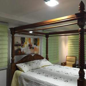 1 cama con dosel de madera en un dormitorio en Sri Kilim Resthouse and Homestay Langkawi, en Kilim
