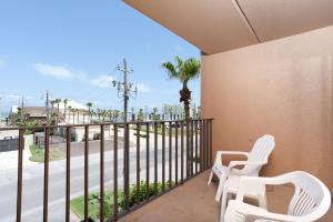 a balcony with two white chairs and a fence at Beachview in South Padre Island