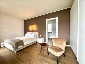 a bedroom with a bed and a chair at Maison Sophie Lake Como Vista Panoramica AC in Dorio