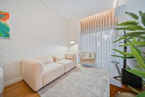 a living room with a white couch and a chair at In-Town Residences in Funchal