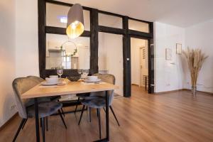 a dining room with a wooden table and chairs at Ferienwohnung Neue Markstraße in Hameln