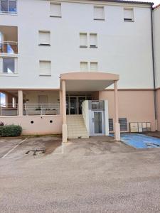 un parcheggio vuoto di fronte a un edificio di Le Mayflower a Le Grau-du-Roi