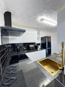 a kitchen with white cabinets and a black counter top at Ensuite Luxury Bedroom In Purfleet in Purfleet +34 photos
