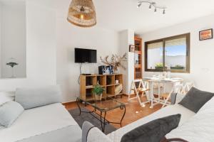 un soggiorno con un divano bianco e un tavolo di Casa Centro wifi,aire acondicionado a Mijas