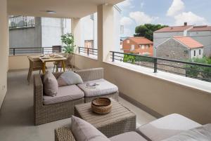 einen Balkon mit einem Sofa und einem Tisch auf dem Balkon in der Unterkunft Modern Apartments Marija in Pakoštane