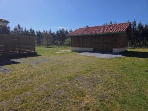a small building in a field with a fence at Maison familiale avec jardin à Lit-et-Mixe, 100 m² in Lit-et-Mixe