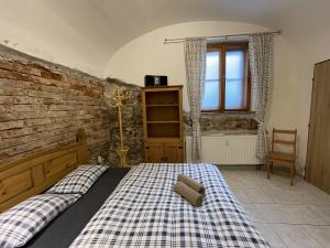 a bedroom with a bed with a checkered blanket at Ospalá díra - Sleepy Hollow in Olomouc