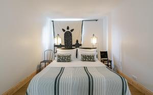 a bedroom with a bed with a black and white bedspread at Domaine de charme pres de Contis in Saint-Julien-en-Born