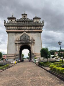 Un gran monumento con un arco en un parque. en Hola Backpacker Hostel, en Vientiane
