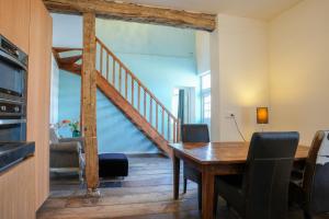 ein Esszimmer mit einem Holztisch und einer Treppe in der Unterkunft Fijn, recent volledig gerenoveerd appartement in Maastricht in Maastricht