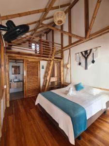 una camera da letto con un letto grande e pavimenti in legno di Intiquilla Hotel a Manta
