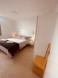 a bedroom with a bed and a wooden chair at CascadaSol in Mogán