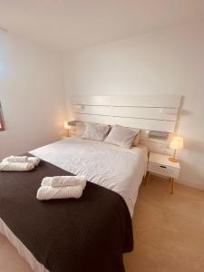 a bedroom with a large bed with two towels on it at CascadaSol in Mogán +71 photos