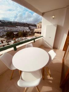 a white table and chairs in a room with a window at CascadaSol in Mogán