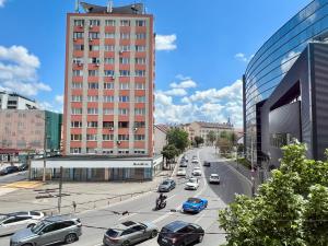 a busy city street with cars and a tall building at Cozynest No 42 in Cluj-Napoca