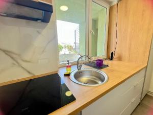 a kitchen counter with a sink and a window at Cozynest No 42 in Cluj-Napoca +13 photos