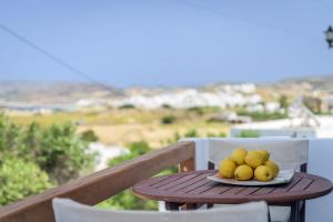 a plate of fruit on a table on a balcony at Nobilis view suite in Plaka Milou