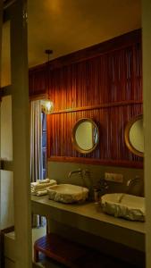 a bathroom with two sinks and two mirrors at Mateves boutique lodge in Arusha +88 photos