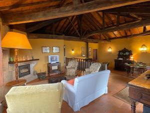 a living room with a white couch and a fireplace at Casa do Vale - Douro Valley Cottage in Resende