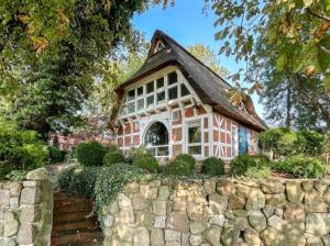a house with a roof on a stone wall at Reetdachtraum in Wischhafen in Wischhafen