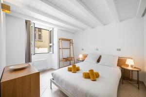 Un dormitorio con una cama blanca grande y una ventana en La Marne, Charming duplex in the heart of downtown Menton, en Menton