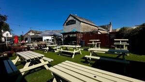a group of picnic tables and benches in a yard at London Inn in Braunton