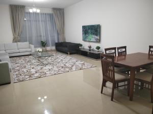 un soggiorno con un tavolo e un divano di Al Khor Tower Apartment ad Ajman