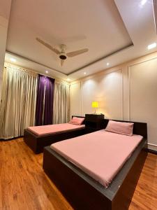 a room with two beds and a ceiling at Modern 2BR Central Apartment Lahore Zameen Opal in Lahore +21 photos