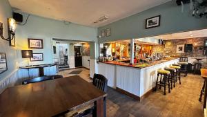 a bar in a restaurant with a table and chairs at London Inn in Braunton