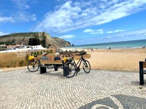 two people sitting on a bench at the beach at Beautiful sea view in Luz