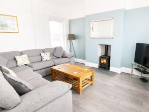 Una sala de estar con un sofá y una chimenea. en 51 Trinity Avenue, en Llandudno