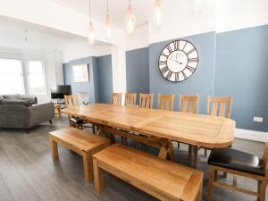 comedor con mesa de madera y reloj en la pared en 51 Trinity Avenue, en Llandudno