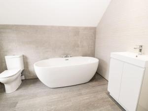 Un baño con un lavabo blanco y un inodoro. en 51 Trinity Avenue, en Llandudno 30 fotos más