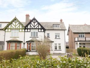 una gran casa blanca con techos blancos y negros en 51 Trinity Avenue, en Llandudno